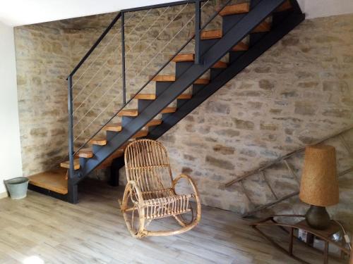 a wicker chair in a room with a staircase at Casa Andreini in Mombarcaro