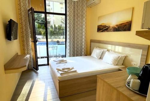 um pequeno quarto com uma cama e uma varanda em Stamopolu Lux ground floor em Primorsko
