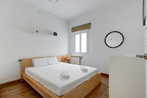 1 dormitorio con 1 cama y reloj en la pared en Barcelona Beach Vibes, en Sant Adrià de Besòs