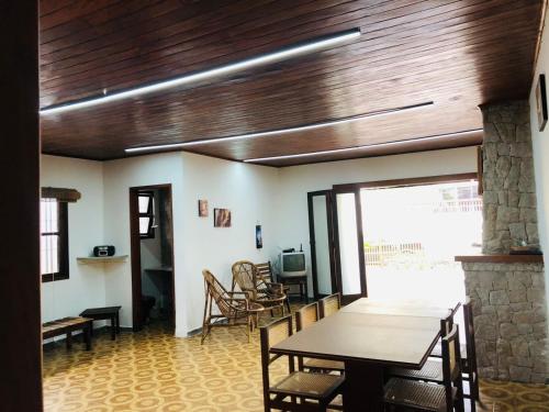 uma sala de jantar com uma mesa e uma lareira de pedra em Casa na Enseada- Guaruja no Guarujá