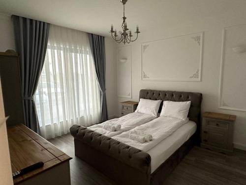 a bed in a bedroom with a large window at M&S Apartament 1 in Baile Felix