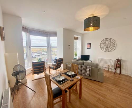a living room with a table and a couch at Bellaview Apartment Barmouth in Barmouth
