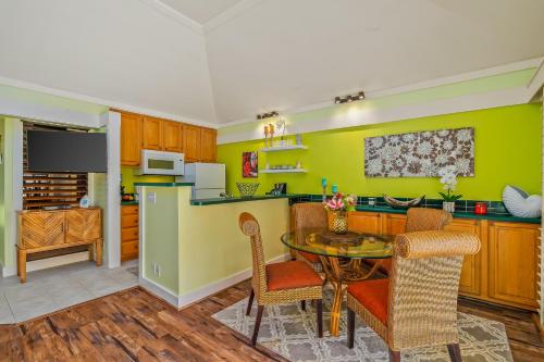 a kitchen with green walls and a table and chairs at Beautiful Poipu 1Br Condo with AC KP237 in Koloa