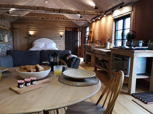 a kitchen and dining room with a table and a room with a bed at Fletchers Bothy in Bosham