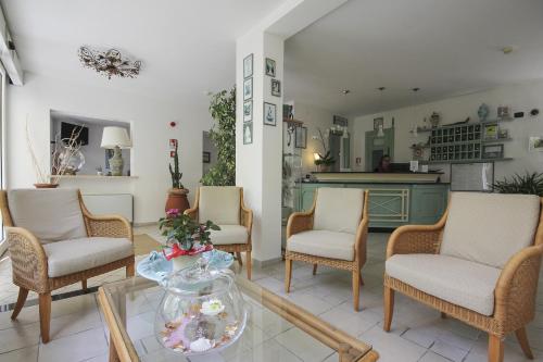 a living room with chairs and a table with a vase at Hotel Miramare in Forte dei Marmi