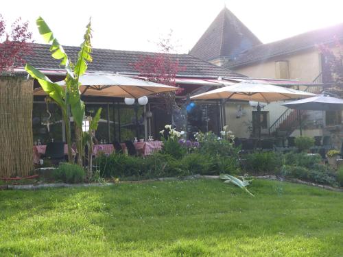 a house with two umbrellas in a yard at Le Domaine du Terroir à 5 minutes des Grottes de Lascaux in La Chapelle-Aubareil