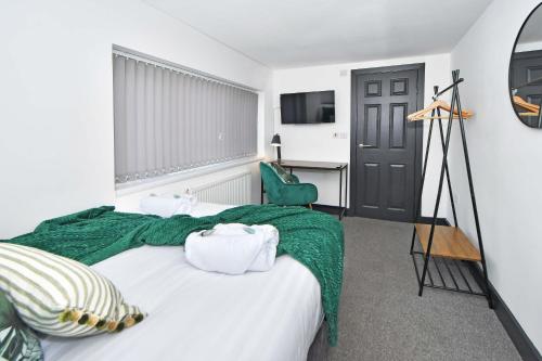 1 dormitorio con 1 cama con manta verde en Adventure Place by YourStays en Stoke on Trent