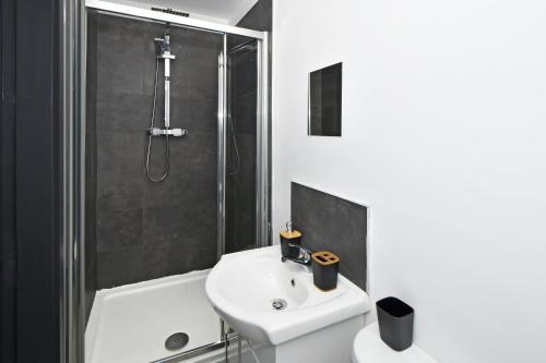 a bathroom with a white sink and a shower at Adventure Place by YourStays in Stoke on Trent