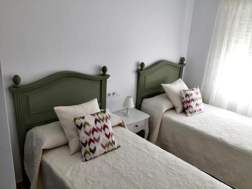 - une chambre avec 2 lits et des oreillers dans l'établissement Casa Iris, à Conil de la Frontera