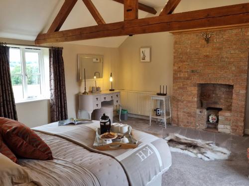 a living room with a bed and a fireplace at Paddock Cottage - Thorpe Arnold Melton Mowbray in Melton Mowbray