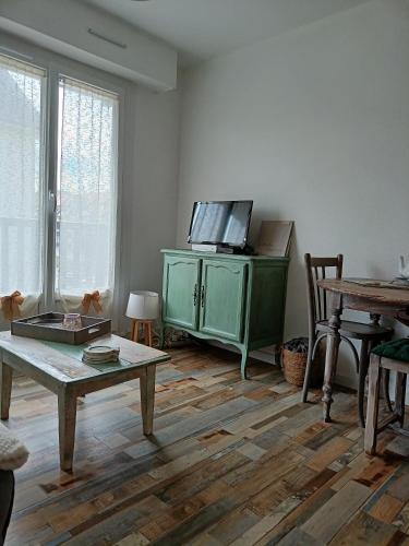 un salon avec une armoire verte et une table dans l'établissement Appartement, à Villers-sur-Mer