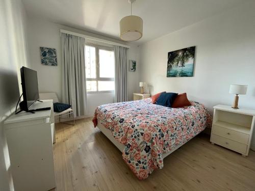 1 dormitorio con 1 cama y TV de pantalla plana en Moderno y hermoso semi piso en Playa Grande en Mar del Plata