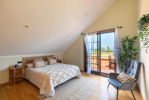 um quarto com uma cama, uma cadeira e uma janela em Espectacular Casa Playa Saians em Vigo