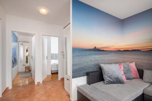 een woonkamer met een bank en uitzicht op de oceaan bij Sunrise Apartment Hvar in Hvar