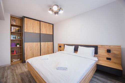 ein Schlafzimmer mit einem großen Bett mit einem hölzernen Kopfteil in der Unterkunft Creamy Wood Haven in Oradea