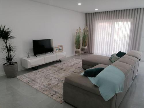 a living room with a couch and a flat screen tv at Alojamento familia Carvalhais in Ponte de Vagos