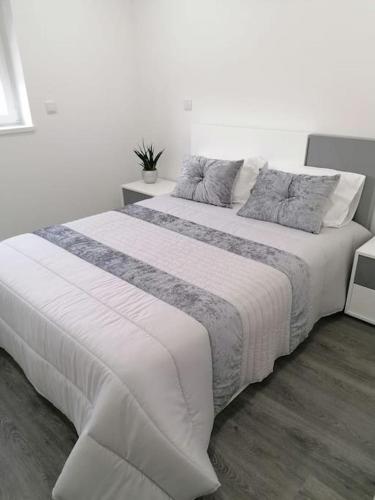 a large white bed in a white bedroom at Alojamento familia Carvalhais in Ponte de Vagos