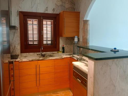 a kitchen with wooden cabinets and a sink at Rentaly Holidays Playa Villaricos in Cuevas del Almanzora