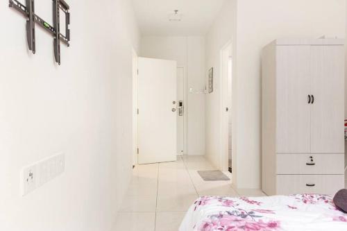a white room with a bed and a white cabinet at Suites Bayan Lepas in Bayan Lepas