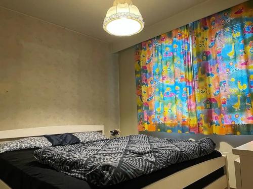 a bedroom with a bed with a large painting on the wall at Holiday Home - Detached house 108m2, 3 rooms, 1 living room, Sauna in Joensuu