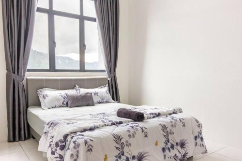 a bed in a bedroom with a window at Suites Bayan Lepas in Bayan Lepas