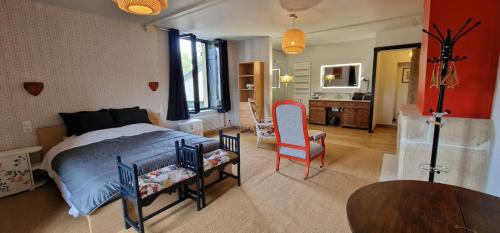 a bedroom with a bed and a table and chairs at La Maison Forte in Millery