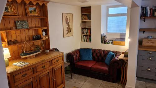 a living room with a couch and a window at Blue Ensign Cottage in Weymouth