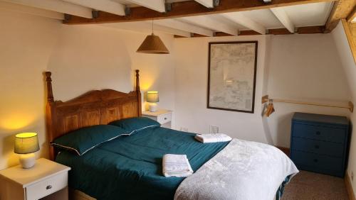 a bedroom with a green bed with two towels on it at Blue Ensign Cottage in Weymouth