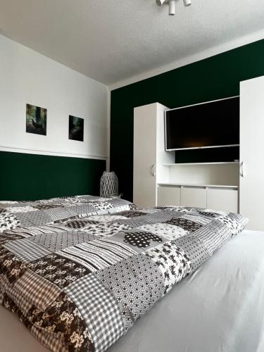 a bedroom with a bed with a black and white comforter at Ferienwohnung zum Scheibe-See in Hoyerswerda