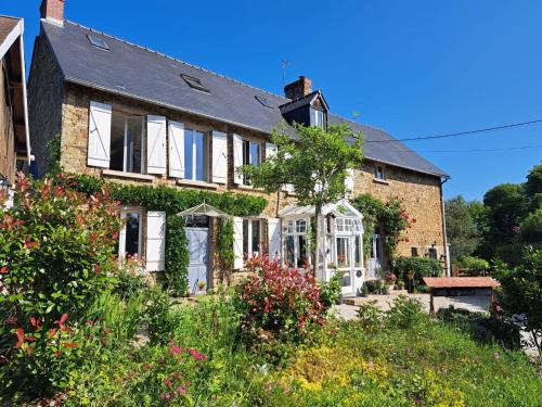 ceglany dom z ogrodem przed nim w obiekcie La Paix, Gîte bucolique en Normandie w mieście Condé-sur-Noireau