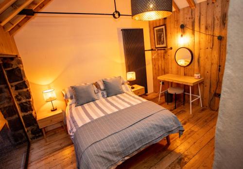 a bedroom with a bed and a table with a mirror at The Woods at Whitepark Bay in Ballintoy