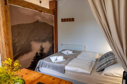 ein Schlafzimmer mit einem Bett mit einem Bild an der Wand in der Unterkunft Apartamenty sudeckie nad zalewem IV in Sosnowka