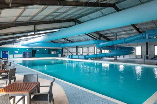 a large swimming pool with blue pipes in a building at Sea view deluxe lodge in Lowestoft