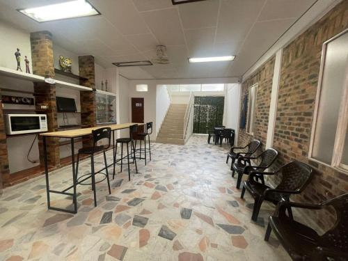 Zimmer mit einer Bar mit Stühlen und einem Tisch in der Unterkunft Alojamiento Yopal in Yopal