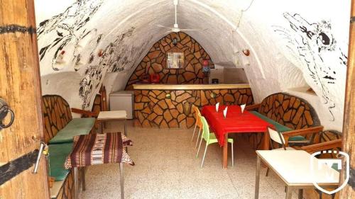 una stanza con tavolo e sedie in una grotta di Touring Club MARHALA MATMATA a Matmata