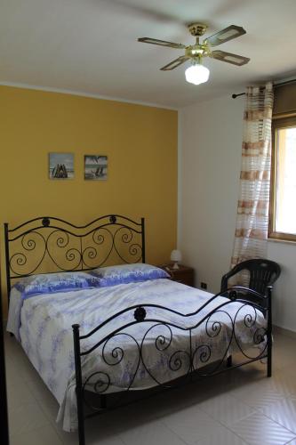 a bedroom with a bed and a ceiling fan at Villa Giù, indipendent villa near airport and sea in Cinisi