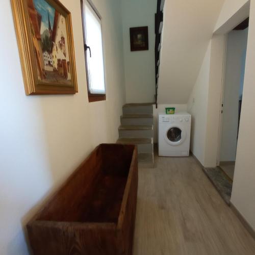 a laundry room with a washing machine and stairs at Le Zie Valdilana in Strona