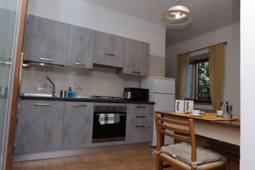 a kitchen with stainless steel appliances and a wooden table at Appartamento Valentina in Levico Terme