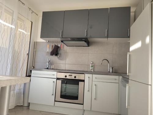 亞維儂的住宿－Appartement Jean Vilar，厨房配有白色橱柜和炉灶烤箱。