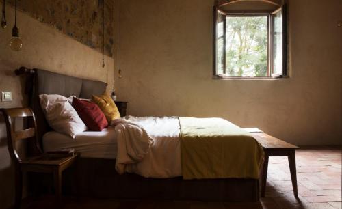 a bedroom with a bed and a table and a window at Agriturismo I Pini in San Gimignano