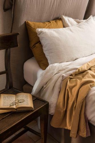 a book sitting on a table next to a bed at Agriturismo I Pini in San Gimignano