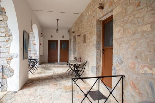 a hallway with a stone wall and a table and chairs at TRADITIONAL HOUSE ALEPIS IN AREOPOLIS in Areopolis
