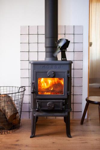 a black stove in a living room with a fire at Knus boshuisje onder de eiken in Ermelo