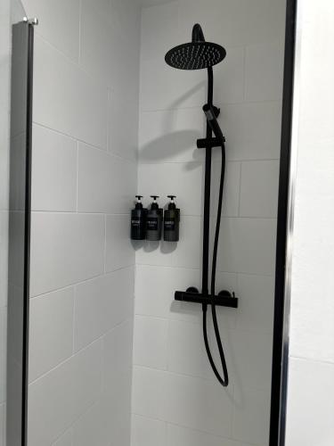 a shower with a glass door with two bottles at Casa Amodiño in Belesar