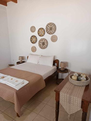 ein Schlafzimmer mit einem Bett und ein paar Platten an der Wand in der Unterkunft Queen Stampalia in Astypalea-Stadt