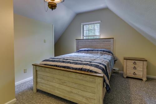 ein Schlafzimmer mit einem Holzbett und einem Fenster in der Unterkunft Cozy Bainbridge Retreat with Fireplace and Deck! 