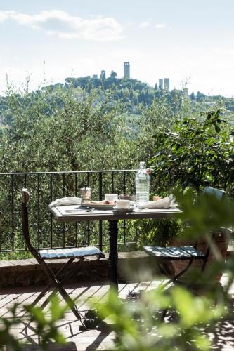 a table with a bottle of water sitting on a balcony at Agriturismo I Pini in San Gimignano
