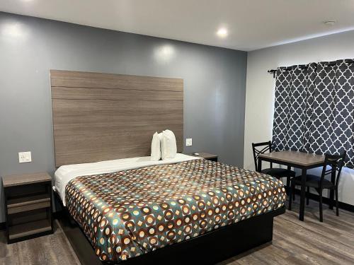 1 dormitorio con cama, mesa y escritorio en Sunshine Motel, en Long Beach