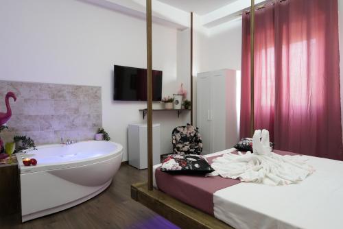a bathroom with a tub and a bed and a bath tub at Airport suite in Catania