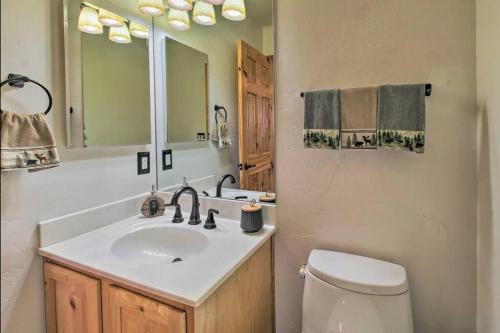 y baño con lavabo, aseo y espejo. en Pine Cone Cabin, en Pinetop-Lakeside